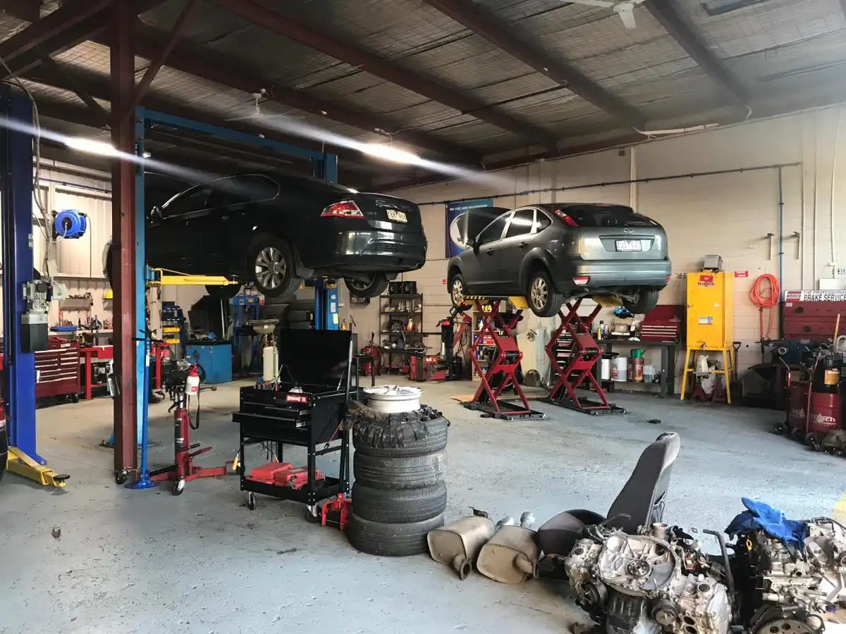 Vehicles on hoists in workshop during car servicing