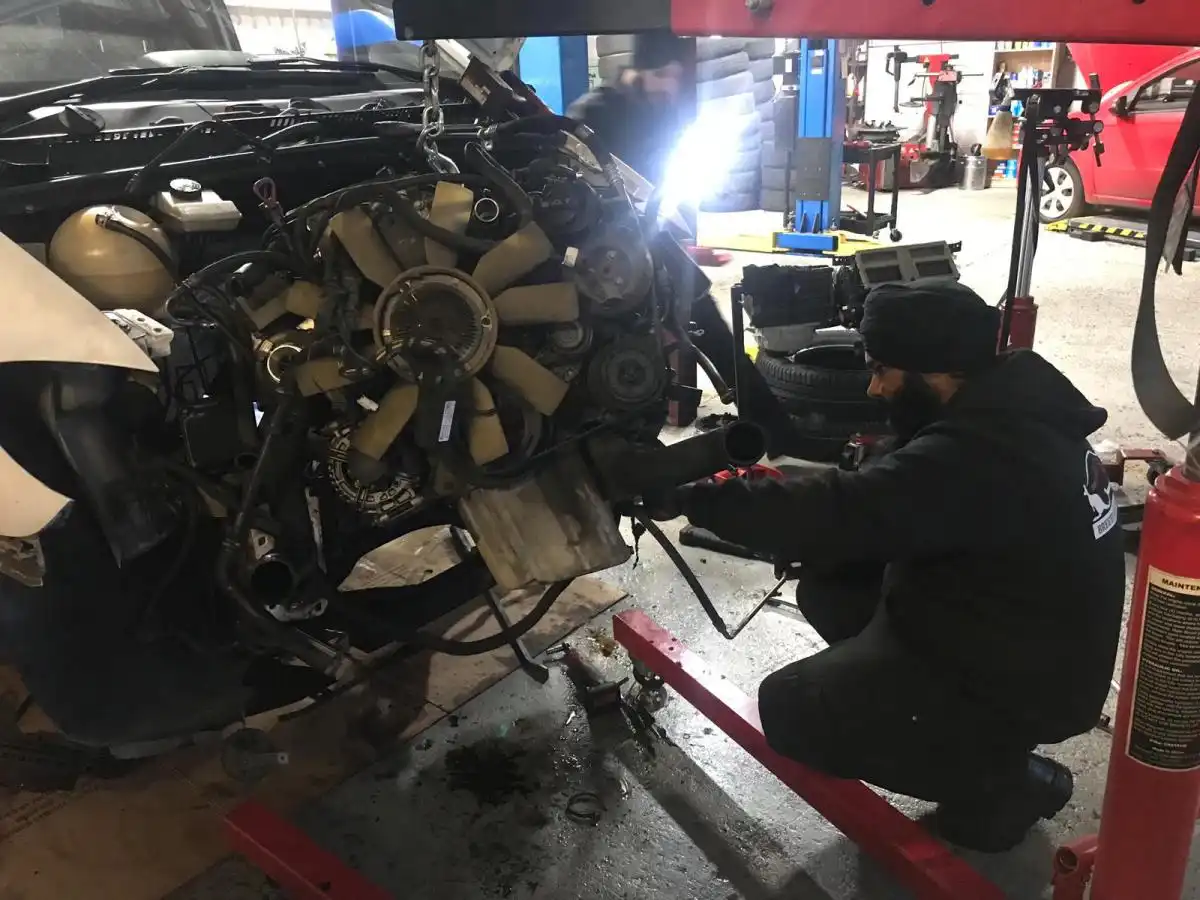 Car mechanic performing engine repair
